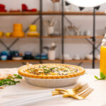 Quiche and breakfast scene in the foreground on a photography studio set with softbox lighting. Colorful dishes are arranged in the background, creating a vibrant and appetizing display. Perfect setup for food photography, showcasing the quiche and breakfast spread with professional studio lighting.