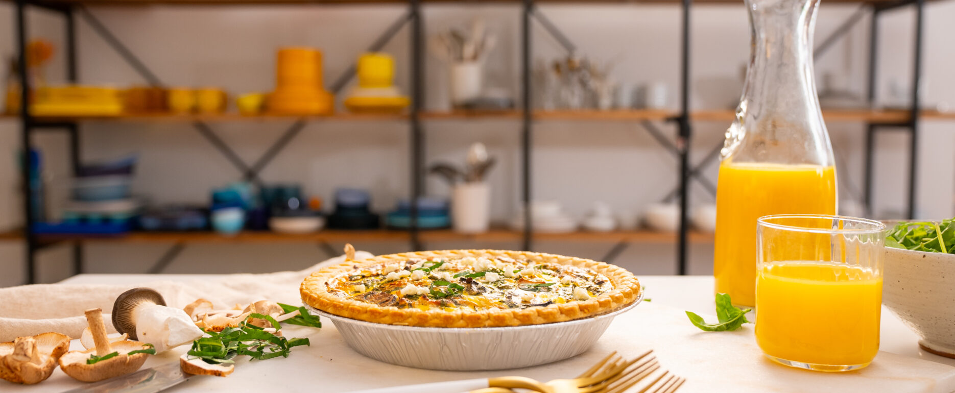Quiche and breakfast scene in the foreground on a photography studio set with softbox lighting. Colorful dishes are arranged in the background, creating a vibrant and appetizing display. Perfect setup for food photography, showcasing the quiche and breakfast spread with professional studio lighting.