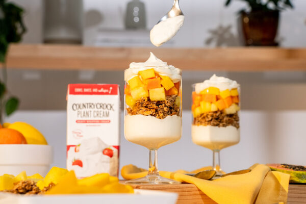Whipped Cream Parfait Fresh fruit parfait topped with a dollop of whipped cream, captured from an enticing top-down angle. The product is prominently featured beside the glass, perfect for showcasing its appeal in vibrant and refreshing food campaigns.