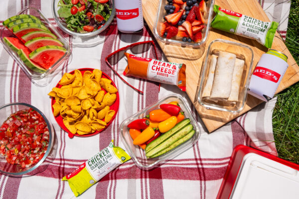 Burritos on a Picnic Blanket Picnic blanket adorned with colorful snacks and burritos, showcasing a variety of flavors in vibrant outdoor lighting.