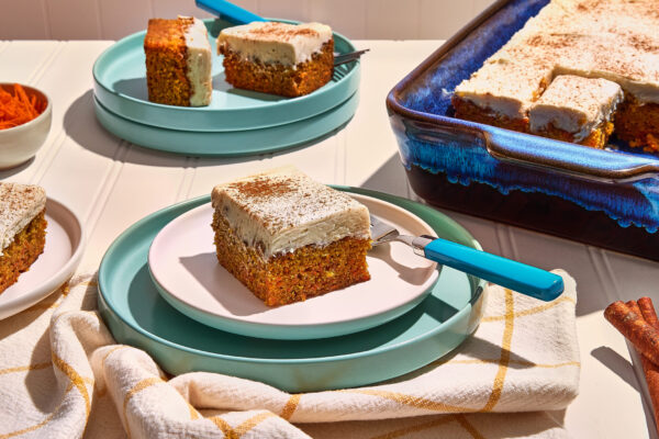 Vegan Carrot Cake Recipe photo of carrot cake elegantly styled on blue plates, meticulously arranged to highlight vibrant pops of color. Ideal for enticing food CPG brands looking to showcase their products in visually appealing and engaging marketing materials.