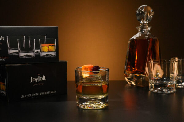 Glassware Featured on Moody Scene Glassware prominently displayed in the center of a moody, dark setting with an orange hue in the background, emphasizing the product's elegant design and atmospheric allure.