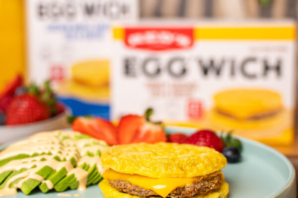 Breakfast Sandwich in Kitchen Studio-lit breakfast sandwiches arranged in a kitchen setting, with a background model wearing an apron, highlighting the delicious appeal and culinary atmosphere.