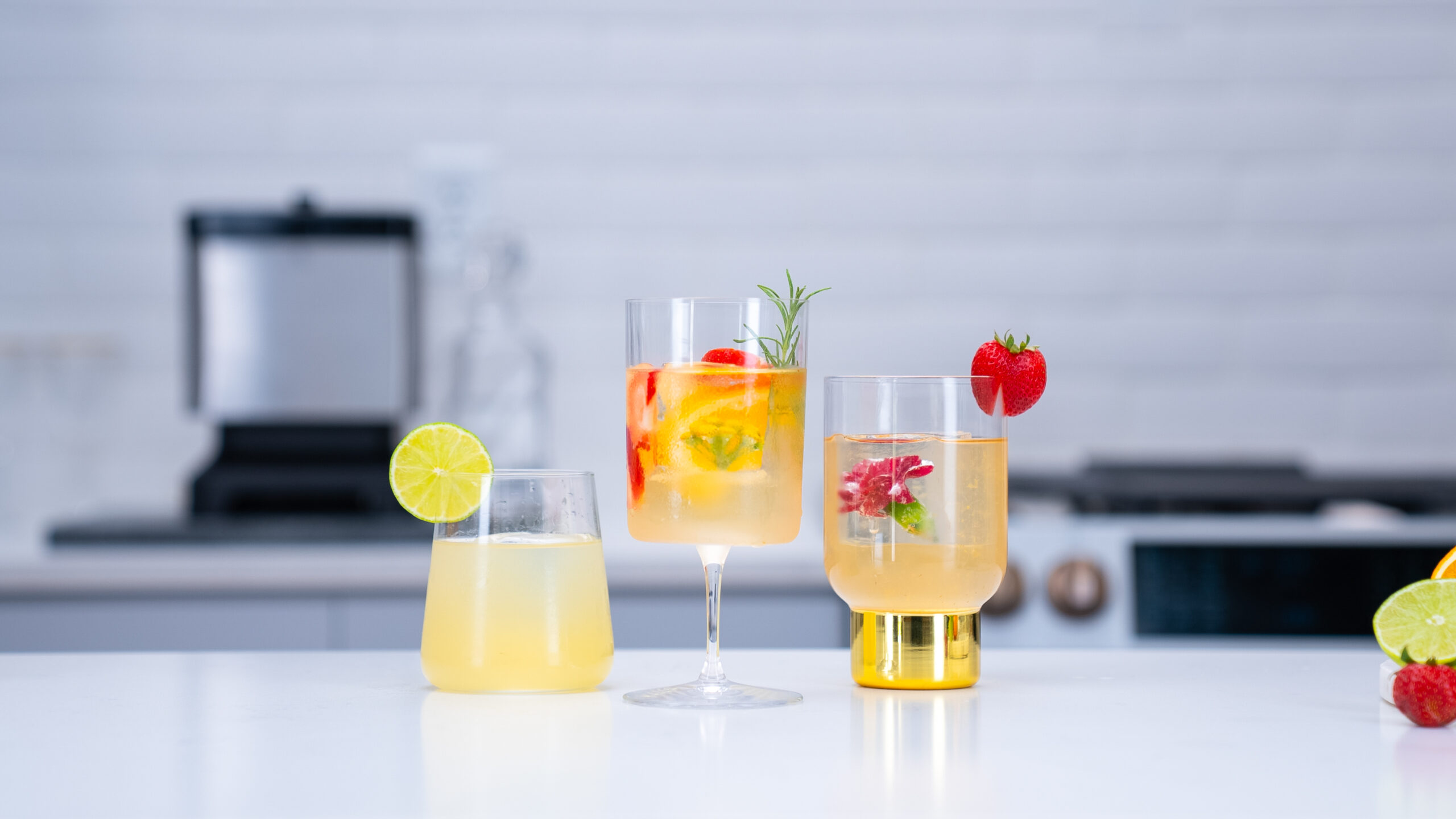 Colorful cocktails with clear ice cubes in a studio lit kitchen.