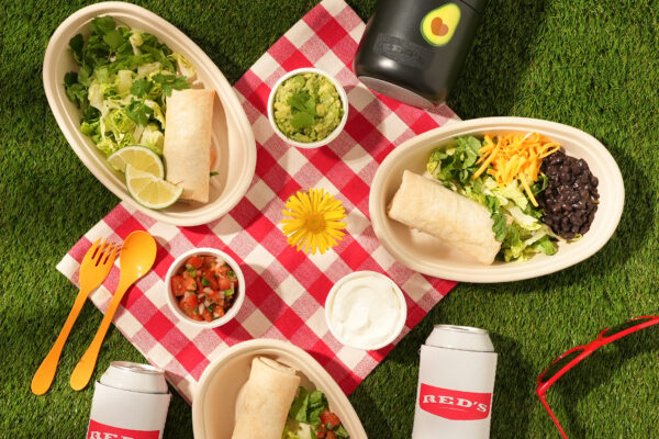 Picnic Burritos Colorful and appetizing burrito bowls with fresh salad on grass, highlighted with guacamole, salsa, and sour cream, perfect for showcasing food brands in a vibrant outdoor setting.